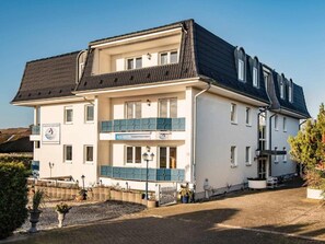 Ein zweigeschossiges Gebäude mit einem Schild für 'Aquarius Fischrestaurant' und einem Balkon mit blauen Geländern.