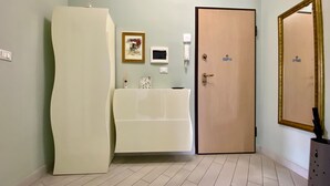 A bathroom with a toilet, sink, and mirror. There is a door with a sign on it and a light switch on the wall. - Il Bumbunin di Collegno – Free Parking in Central Location (Collegno)