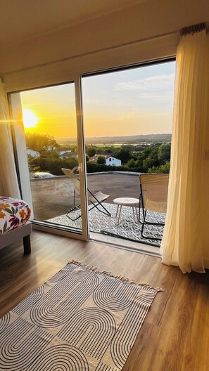 A room with a large sliding glass door leading to an outdoor patio with a view of the countryside. - A little haven of peace in the heart of the Basque country (Urcuit)