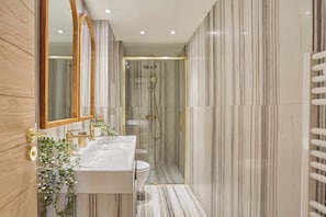 Un bagno moderno con doppio lavabo, cabina doccia in vetro e specchio con cornice in legno.