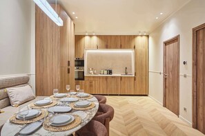 A modern kitchen with wooden cabinets, a built-in oven, and a countertop. - Superbe Apartment with AC Le Marais Beaubourg (Paris)