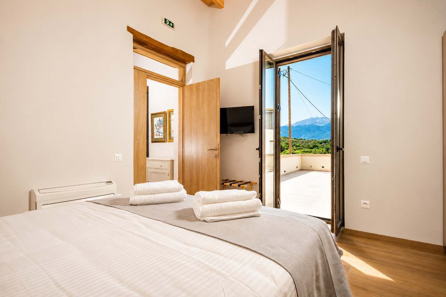 Enjoy natural light and easy access to outdoor spaces from this double bedroom, designed to provide comfort, privacy, and a relaxing holiday experience