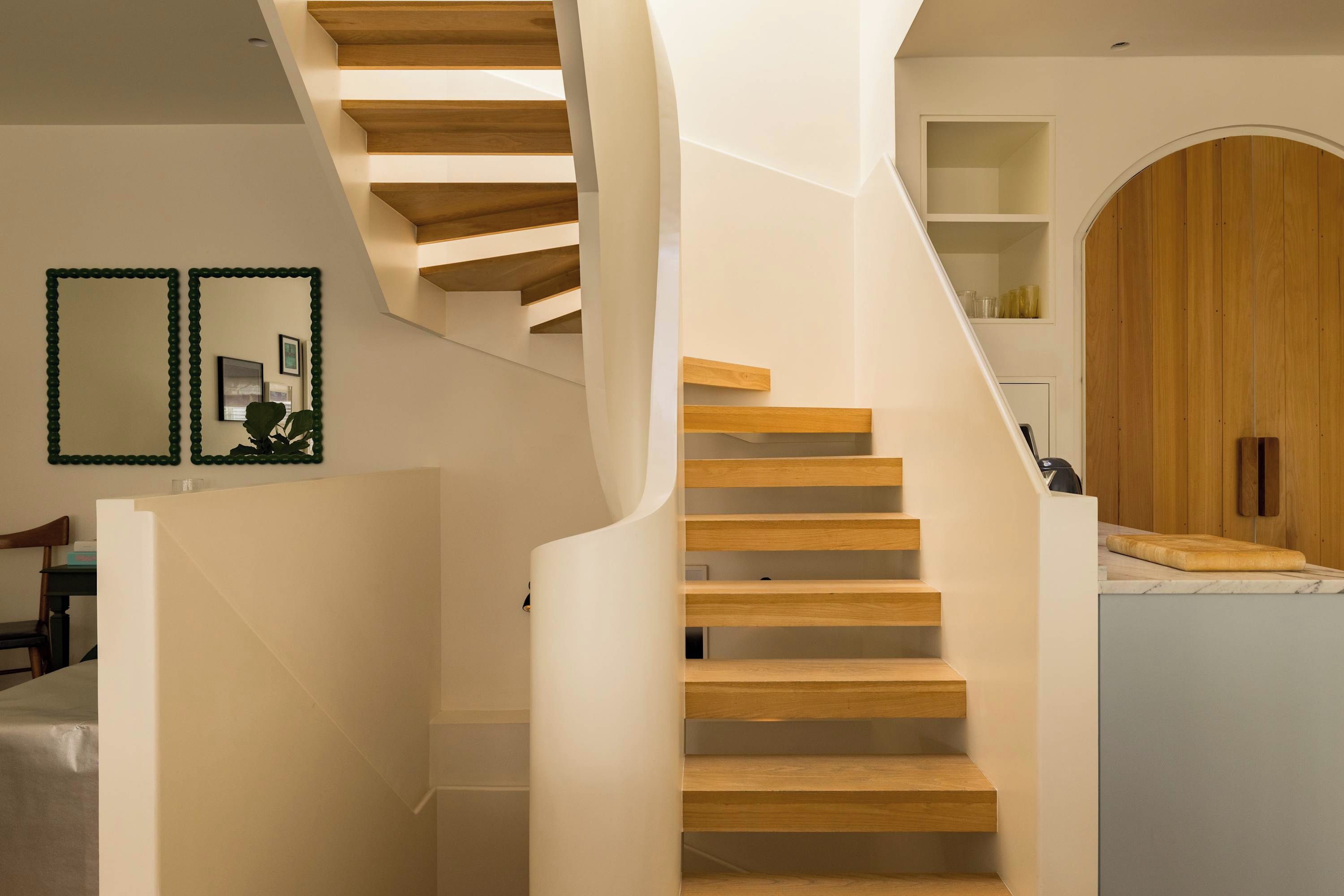 Un escalier moderne avec des marches en bois et des murs blancs.