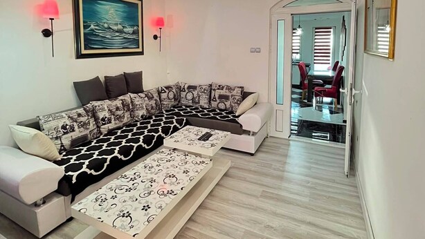 Een moderne woonkamer met een hoekbank, een salontafel en een dakraam.
