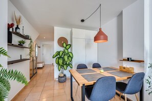 Ein moderner Essbereich mit einem Holztisch, blauen Stühlen und einer hängenden Pendelleuchte.