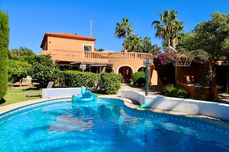 A swimming pool with a fountain, surrounded by greenery and a building with a tiled roof.. Holiday Home 'Villa Da Silva' with Mountain View, Wi-Fi and Air Conditioning