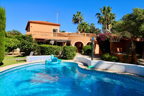 A swimming pool with a fountain, surrounded by greenery and a building with a tiled roof. - Holiday Home 'Villa Da Silva' with Mountain View, Wi-Fi and Air Conditioning (Santa Llucia)
