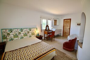 A bedroom with a bed, a desk, a chair, a bathroom, and a door. - Holiday Home 'Villa Da Silva' with Mountain View, Wi-Fi and Air Conditioning (Santa Llucia)