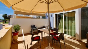 A terrace with a table and chairs, a potted plant, and a large umbrella. - Holiday Home 'Grecia' with Mountain View, Wi-Fi and Air Conditioning (Vergel)