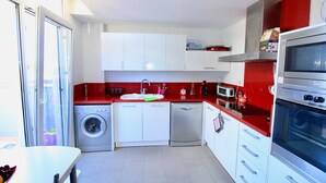A compact kitchen with a washing machine, dishwasher, microwave, and oven. - Holiday Home 'Grecia' with Mountain View, Wi-Fi and Air Conditioning (Vergel)