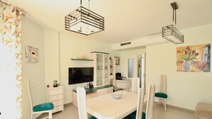 A dining area with a table, chairs, a television, and a cabinet. - Holiday Home 'Grecia' with Mountain View, Wi-Fi and Air Conditioning (Vergel)