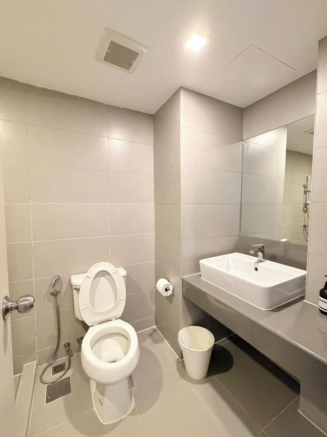 A modern bathroom with a toilet, sink, and shower.