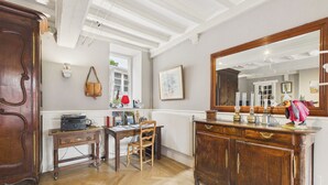 Une pièce avec un meuble en bois, un bureau avec une chaise, un grand miroir et une fenêtre donnant sur un beau paysage.
