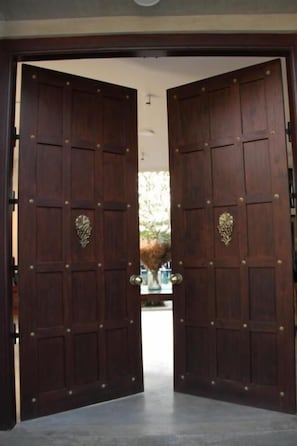 Un conjunt de portes de fusta dobles amb una finestra central, que donen pas a una zona exterior.