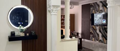A modern interior with a round mirror, a television, and a decorative wall.