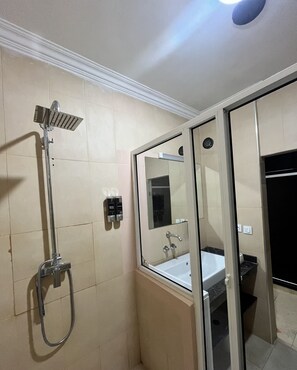 Ein Badezimmer mit Dusche, Waschbecken und Spiegel.