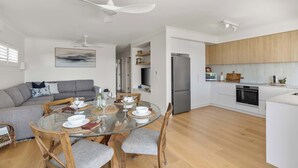 Una cocina moderna con gabinetes blancos, un refrigerador de acero inoxidable y un horno.