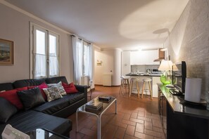 Ein kompakter Wohnbereich mit Sofa, Couchtisch, Küchenzeile und Esstisch.