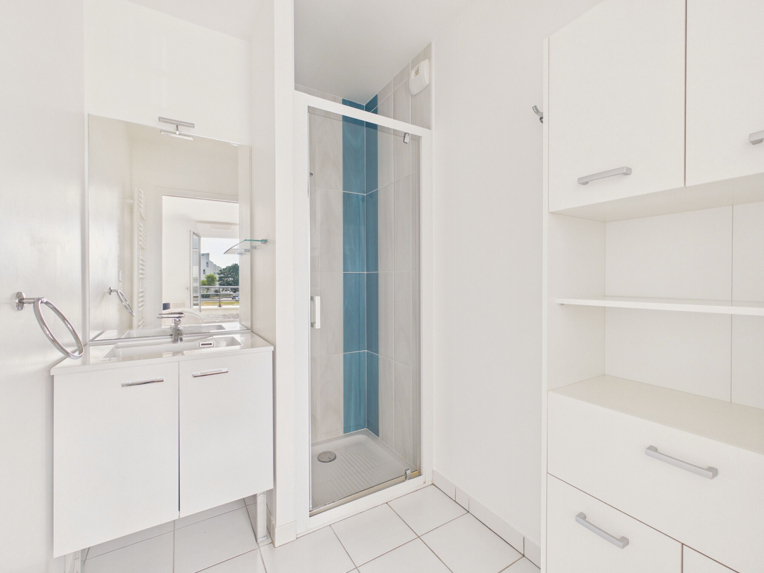 A modern bathroom with a shower, a sink, and a mirror.