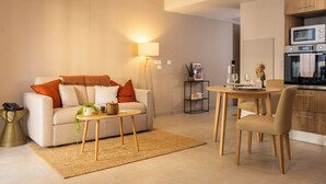 Uma sala de estar moderna com sofá, mesa de centro e área de jantar.