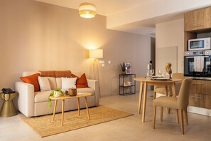Una sala de estar moderna con un sofá, una mesa de centro y una zona de comedor.
