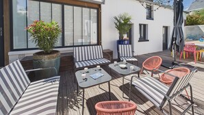 A deck with striped sofas, a table with cups, and potted plants. - Superb house for 10, near beach (Dinard)