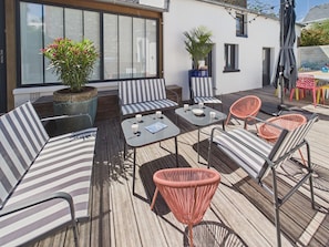 A deck with striped sofas, a table with cups, and potted plants. - Superb house for 10, near beach (Dinard)