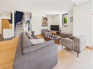 A modern living room with a sofa, armchairs, a coffee table, and a TV. - Superb house for 10, near beach (Dinard)