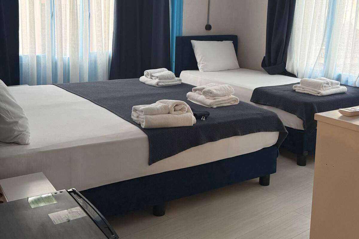 Habitación de hotel con dos camas, un escritorio y un armario.