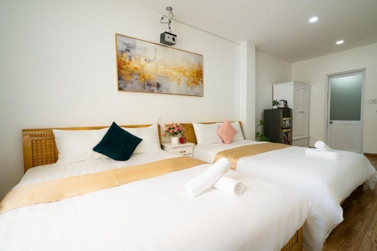 Een hotelkamer met twee bedden, een schilderij aan de muur, een kledingkast en een deur.