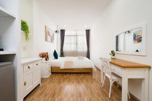Un dormitorio con cama, mesita de noche, silla y escritorio.