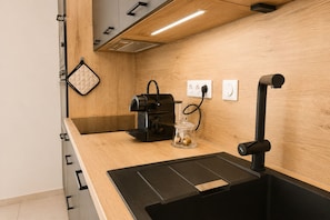 Eine Küche mit Kaffeemaschine, einem Glasbehälter und einer schwarzen Arbeitsplatte.