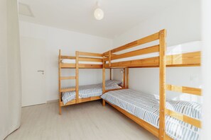 A room with two bunk beds, a door, and a light fixture.