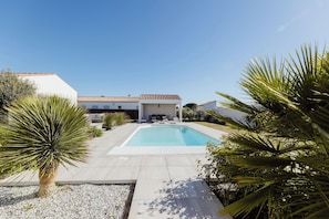 A swimming pool with a patio area, surrounded by white walls and a tiled roof. - Villa Tikaz 4* Ile d'Oléron 8 people swimming pool (Saint-Denis-d'Oléron)