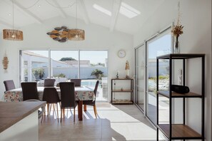 A modern dining area with a table, chairs, and a view of the outdoors.