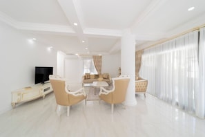 A spacious living room with a sofa set, a coffee table, and a television.