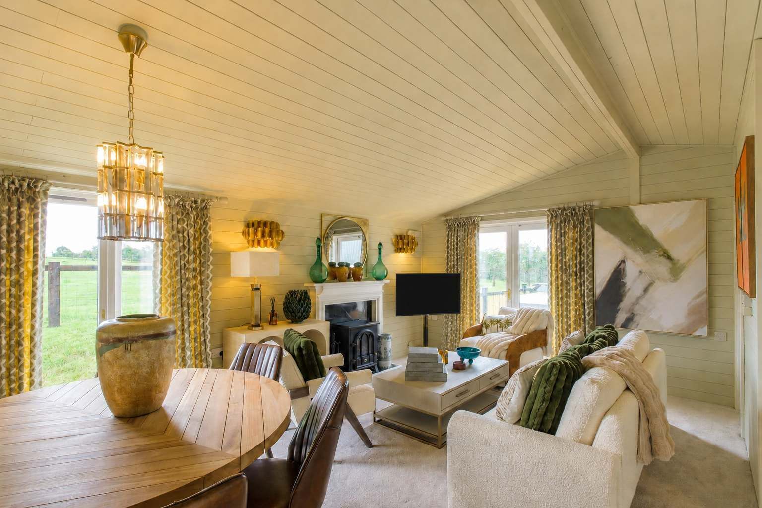 A cozy living room with a fireplace, a television, and a dining area with a wooden table and chairs.