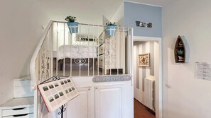 A staircase leading to a bed with a view, a 'BEACH HOUSE' sign, a welcome sign, and a framed picture on the wall. - Second Lake House - Affitti Brevi Italia (Malgrate)