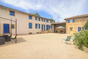 A courtyard with outdoor seating, a barbecue area, and a stone building with blue shutters. - Le Clos Vinzelles - House + outbuilding in the heart of the vineyards, large garden (Vinzelles)