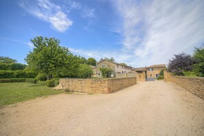 A large house with a gravel driveway and stone walls, surrounded by greenery and trees. - Le Clos Vinzelles - House + outbuilding in the heart of the vineyards, large garden (Vinzelles)