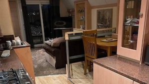 A compact kitchen with a dining area, a sofa, and a view through a glass door. - 2 Bed - Sleeps 6 - Lake View - Beach Access - Pets (Skegness)