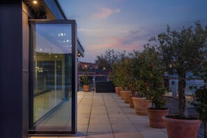 A modern building with a glass entrance, potted plants, and a clear sky. - Luxury two Story Penthouse With Roof top Terrace (Shrewsbury)