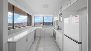 Une cuisine moderne offrant une vue sur le paysage urbain grâce à de grandes fenêtres.
