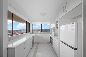 Eine moderne Küche mit Blick auf eine Stadtlandschaft durch große Fenster.