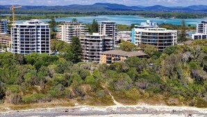 Une zone côtière avec de nombreux immeubles de grande hauteur, une plage de sable et des eaux turquoise cristallines.