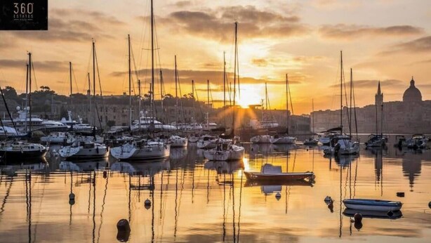 A marina with multiple boats docked at sunset.