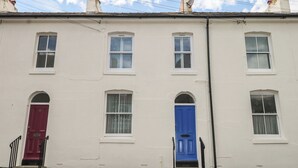A row of white terraced houses with distinct red and blue doors. - Foreshore (Deal)