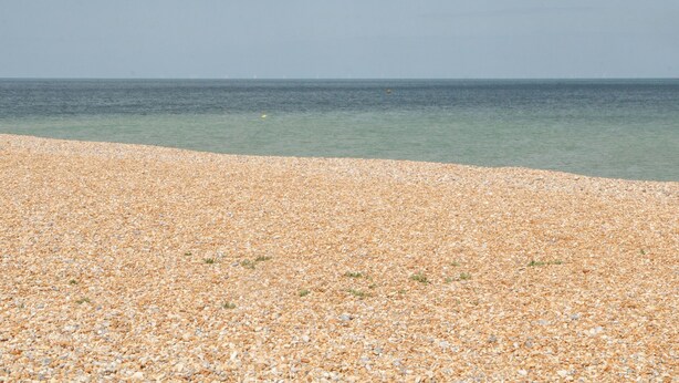 A pebbled beach with clear water and a distant horizon. - Foreshore (Deal)