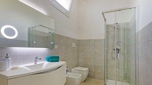 A modern bathroom with a glass-enclosed shower, a large mirror, and a white vanity. - Spacious two-level apartment, ideal for four people, with two bedrooms, two bathrooms, private parking, and a pleasant furnished internatl garden for relaxing outdoors. Located in the center of Campi Salentina, in a quiet residential area, it's just a 15 (Campi Salentina)