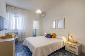 Une chambre à coucher avec un lit, une table de chevet, une lampe et une chaise.